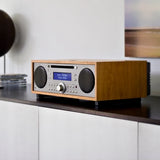 Tivoli Audio Music System+ in Cherry Taupe, elegant wood-finish hi-fi sitting on a black cupboard