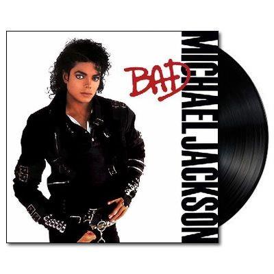 A vinyl LP record of Michael Jackson's album 'Bad' with the artist's picture and the album title in red letters on the cover.