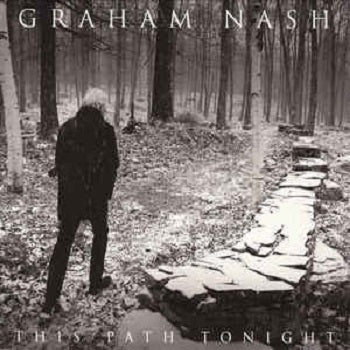 Graham Nash standing in a forest setting, looking towards a stone path, with trees in the background. The album 'This Path Tonight' is visible on the vinyl record.