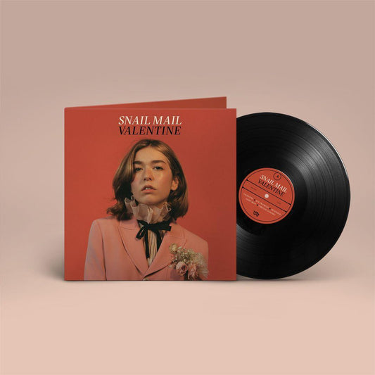 A vinyl LP of Snail Mail's album 'Valentine' with a red cover featuring the artist's photo and tracklist.